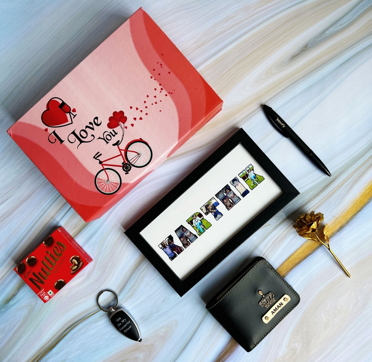 I Love You Box hamper 1.0 You can gift it as a heartfelt gift to your husband on Anniversary to make things more precious. It has a Beautiful Combo Includes a I Love You box, Men wallet 1.0, Black vector Pen, Drive Safe Led Keychain, Name Frame 4x8 inches, Nutties and Gold rose.