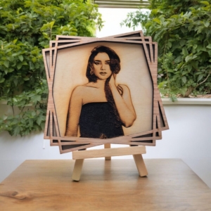 Custom 3D wood carved poster displayed in a personalized engraved wooden photo frame with a sturdy wooden stand, showcasing natural wood grain texture and unique design