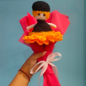 A handmade crochet sunflower that transforms into a doll, wrapped in red wrapping paper.