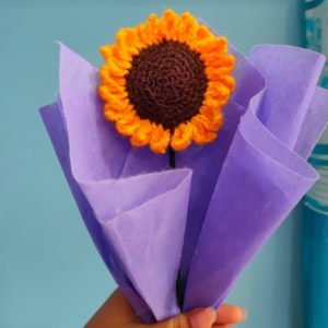 Handmade customizable single sunflower crochet bouquet wrapped in purple paper