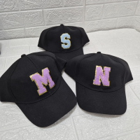 Personalized letter initial cap with glittery monogram, available in multiple colors including red, black, and white. No color choice for the monogram.