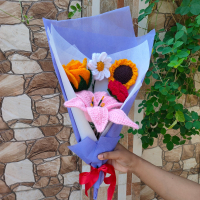 Custom crochet flower bouquet featuring a daisy, yellow rose, red rose, sunflower, and lily.