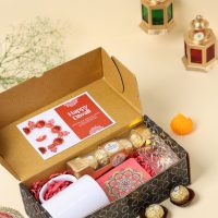 Diwali gift box with Ferrero Rocher chocolates, white ceramic mug, candle holder, and festive rangoli card.